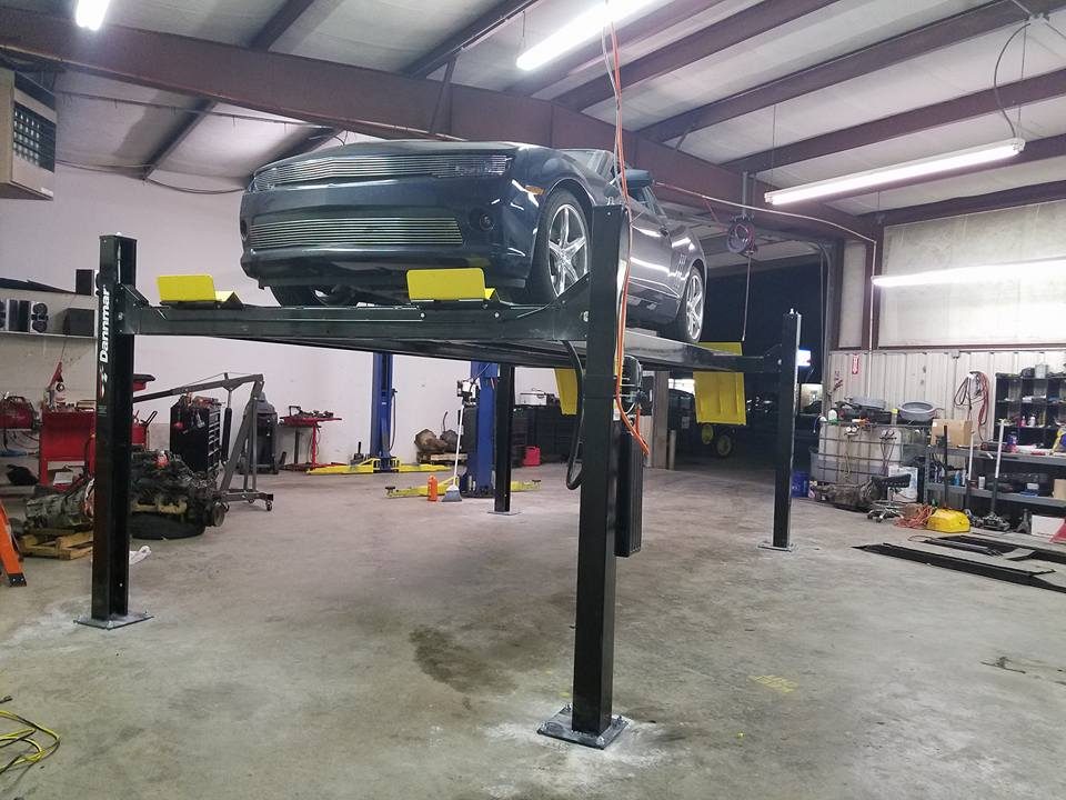 A customer's vehicle up on the lift inside the Armstrong Automotive shop