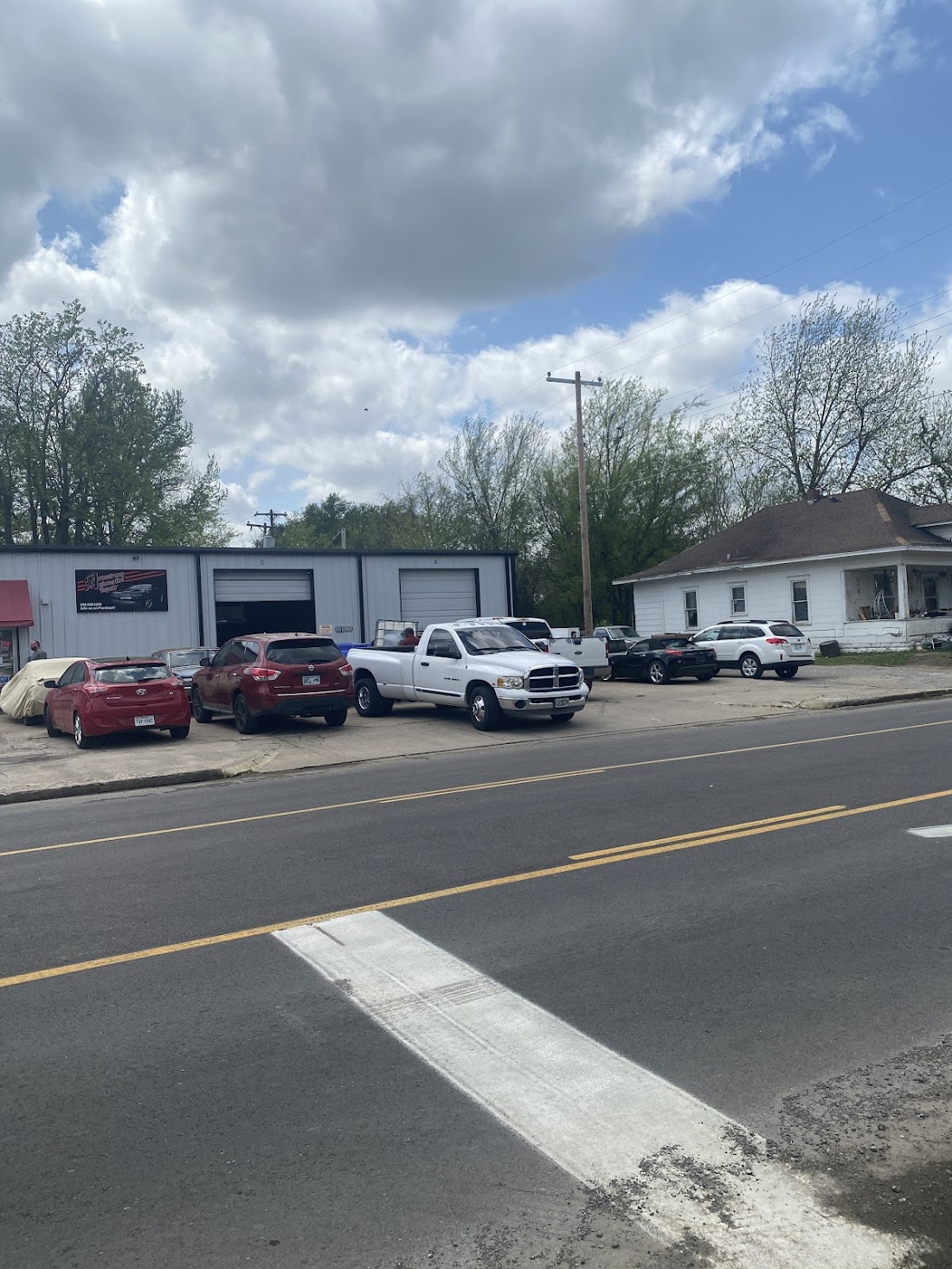 Armstrong Automotive Repair storefront on Gibson Street with customer vehicles parked outside
